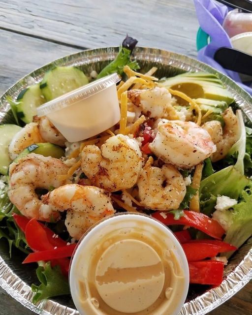 A salad with shrimp and dressing in it.