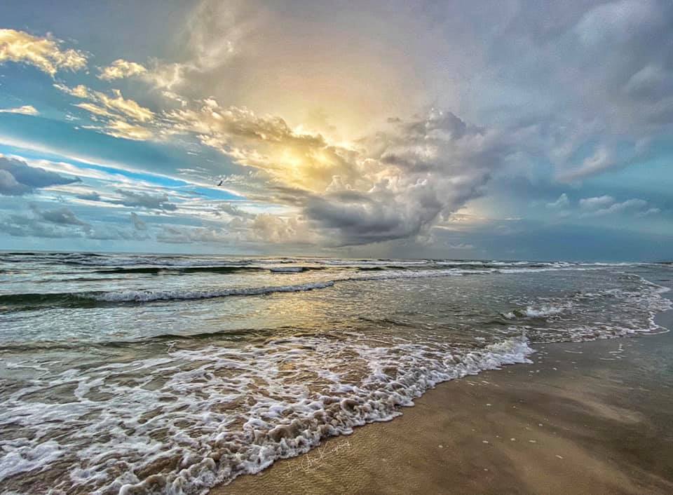 A beach with waves coming in from the ocean.