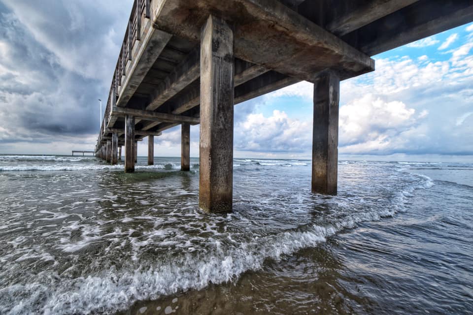 A pier with waves coming in from the ocean.