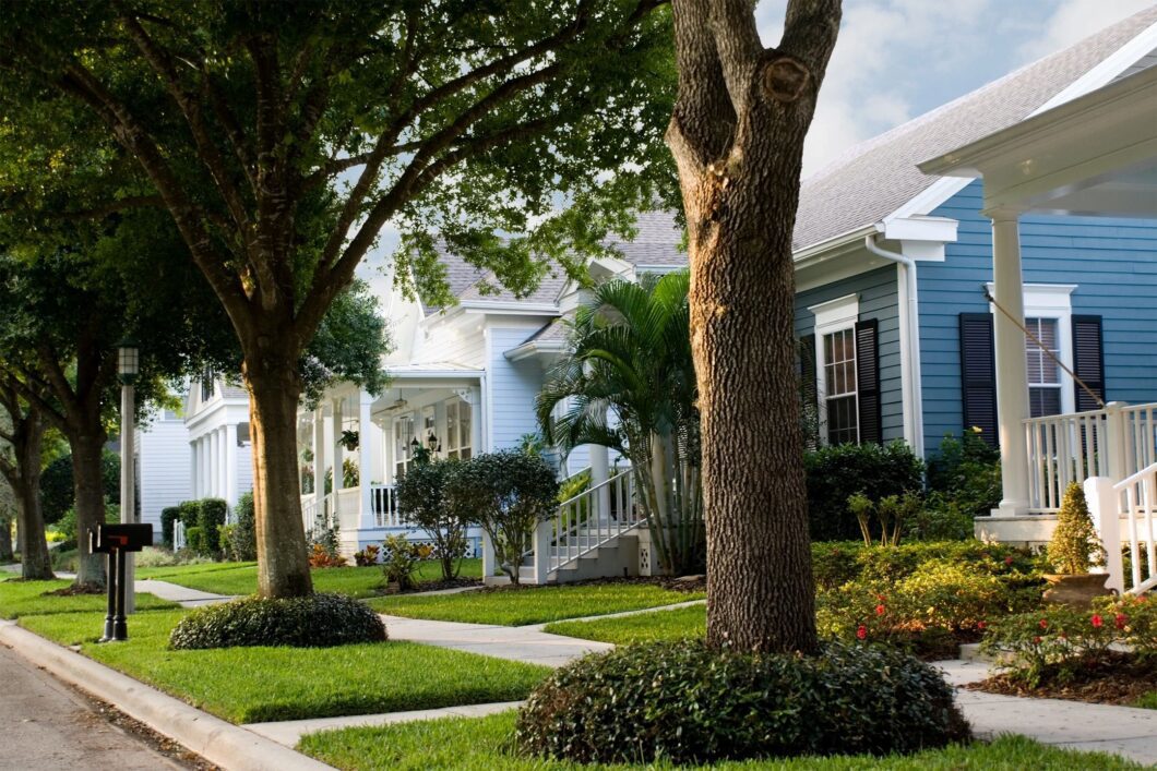A row of houses with trees in the front yard.