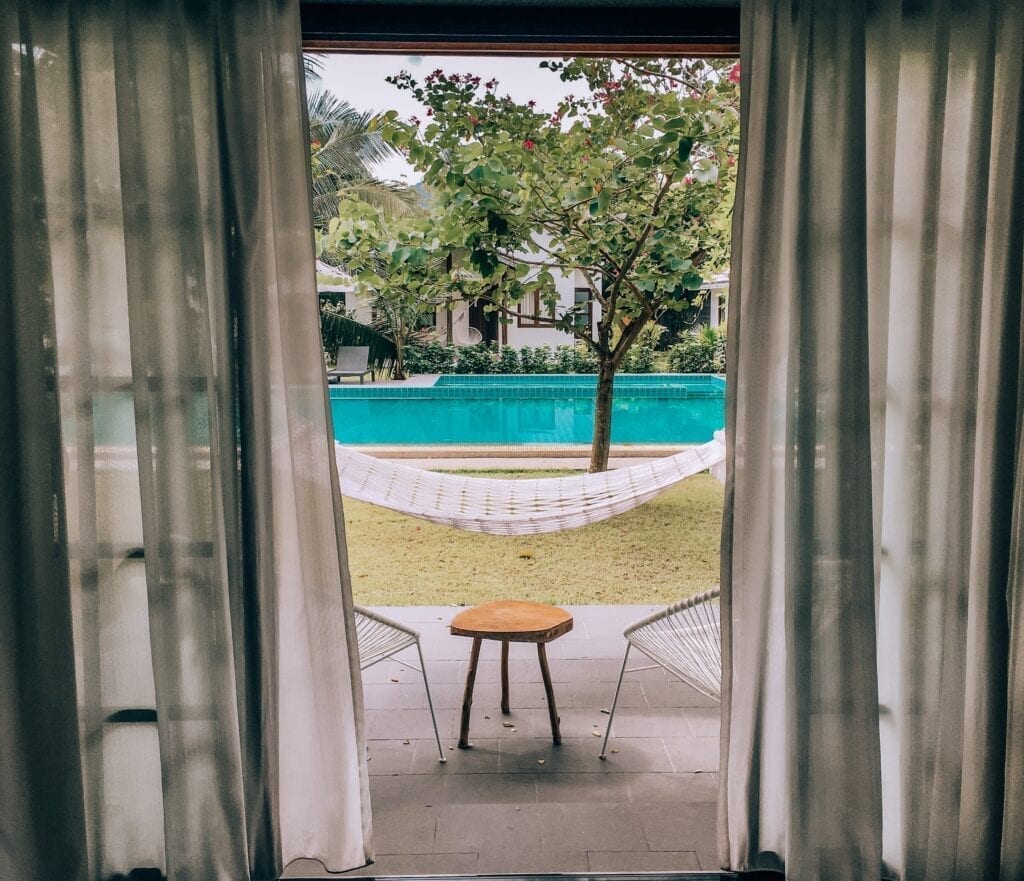 A view of a pool from an open door.