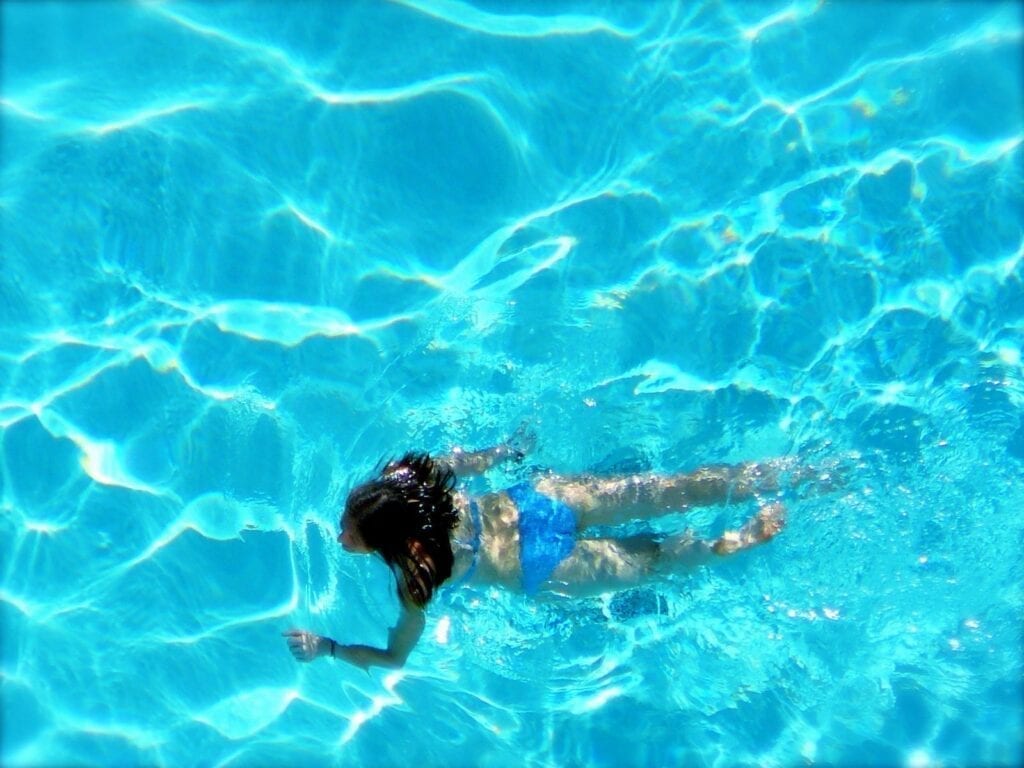 A person swimming in the water with their arms out.