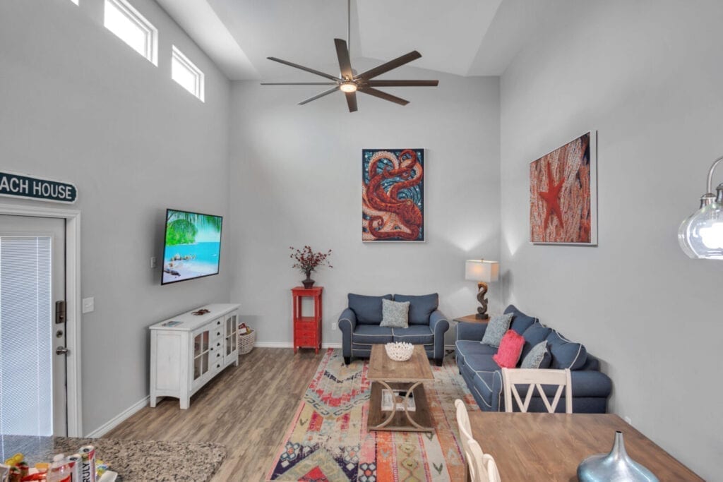 A living room with a couch, chair and television.