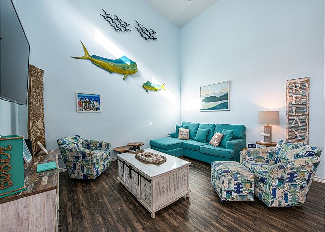 A living room with blue furniture and fish decorations.