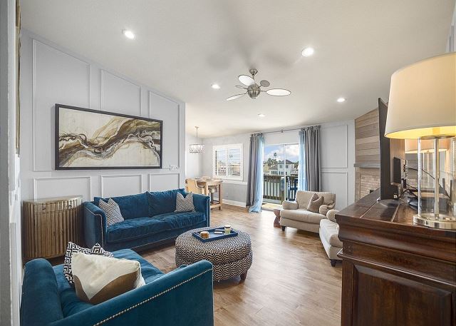 A living room with blue couches and white walls