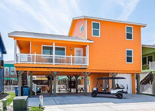 A house with an orange exterior and a golf cart parked in front of it.