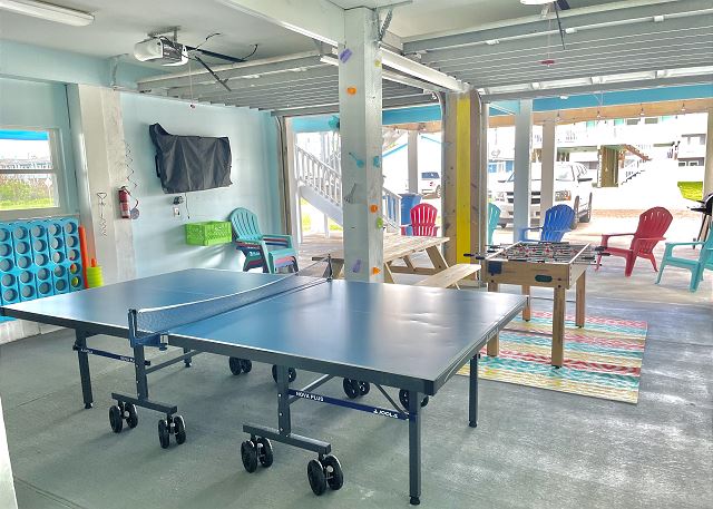 A ping pong table in the middle of an indoor area.