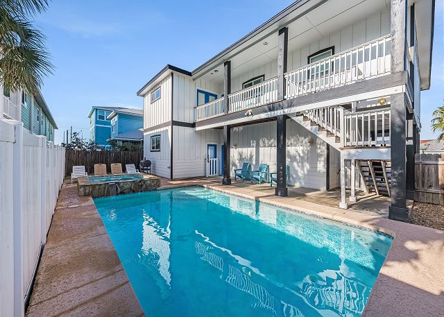 Outdoor swimming pool beside a modern two-story building with balconies.
