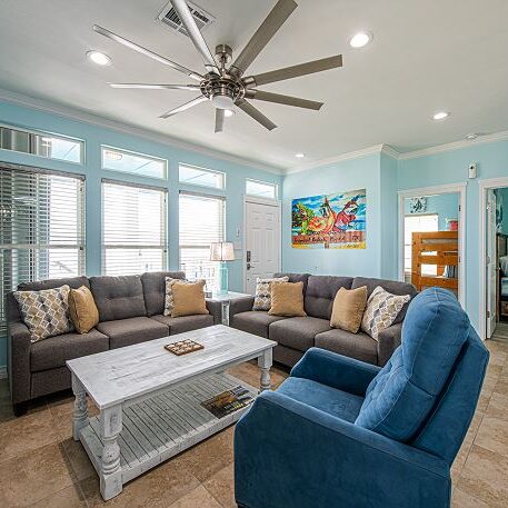 A living room with couches, chairs and tables.