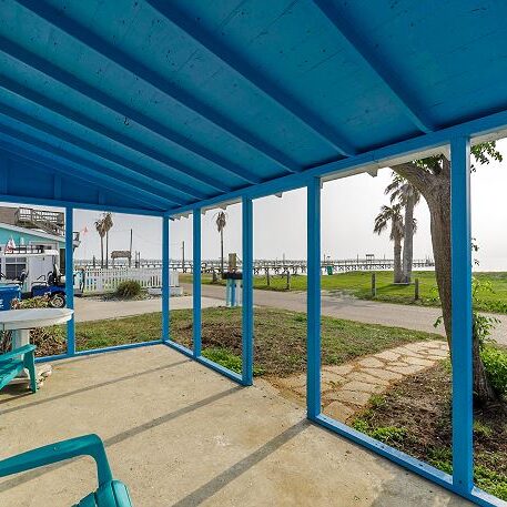 A blue covered patio with chairs and tables.