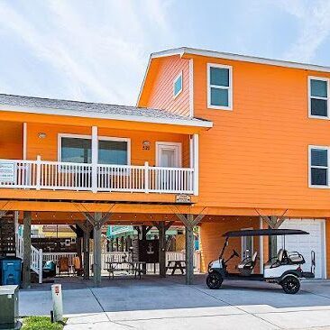 A house with an orange exterior and a golf cart parked in front of it.