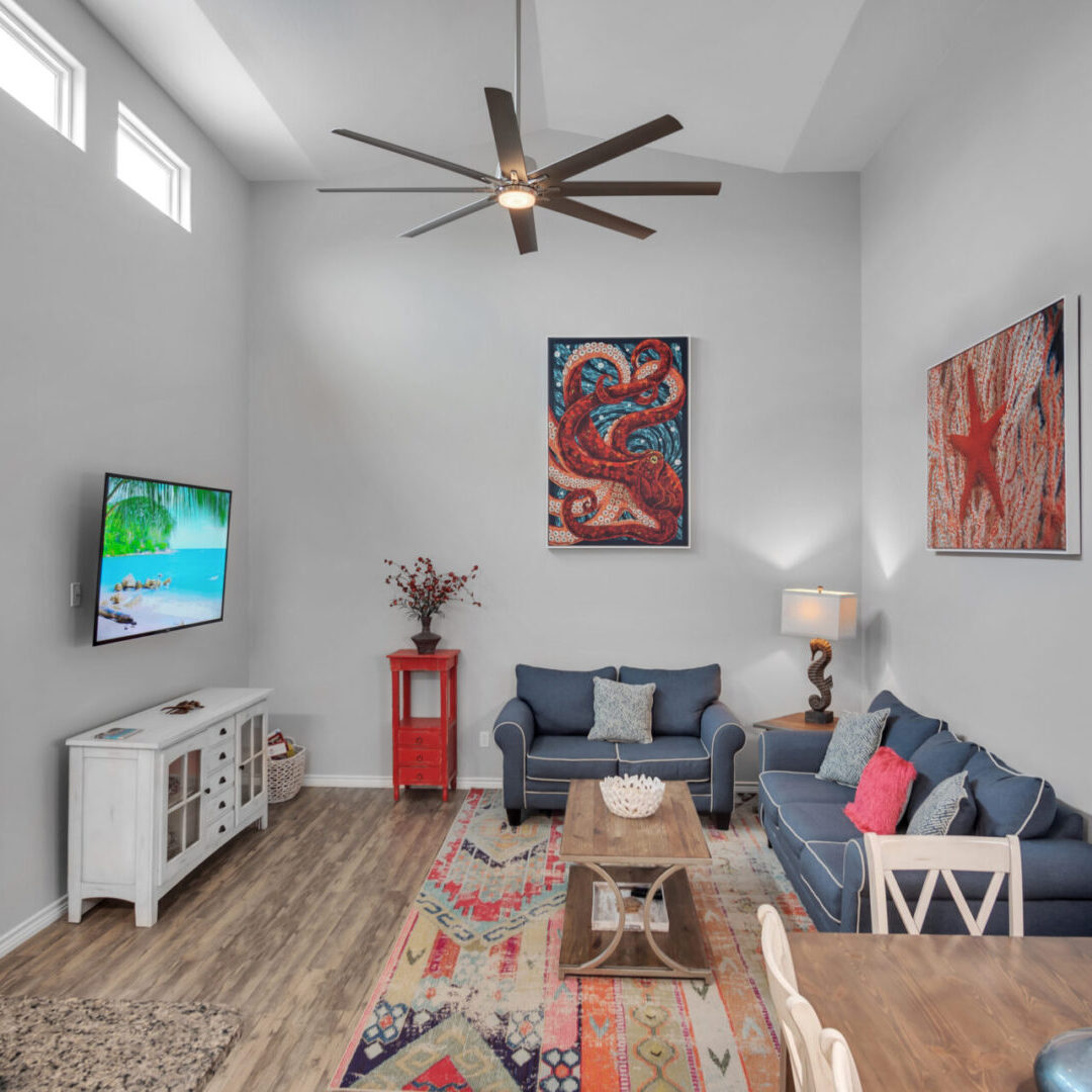 A living room with a couch, chair and television.